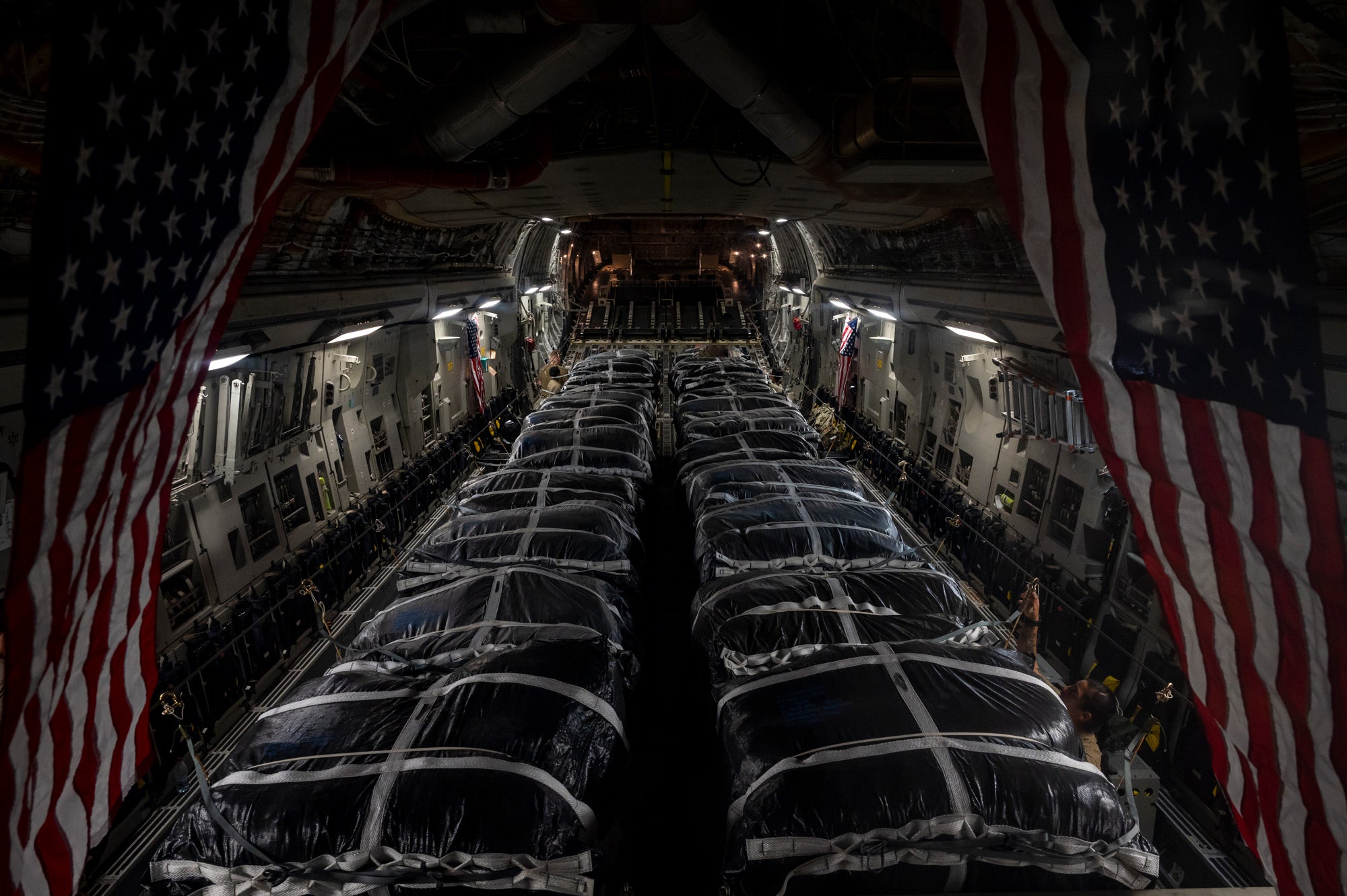 22 Low velocity parachutes loaded into this cargo plane. Each parachute can drop up to 2,200 pounds. That would be 48,400 pounds if these payloads are maxed out.