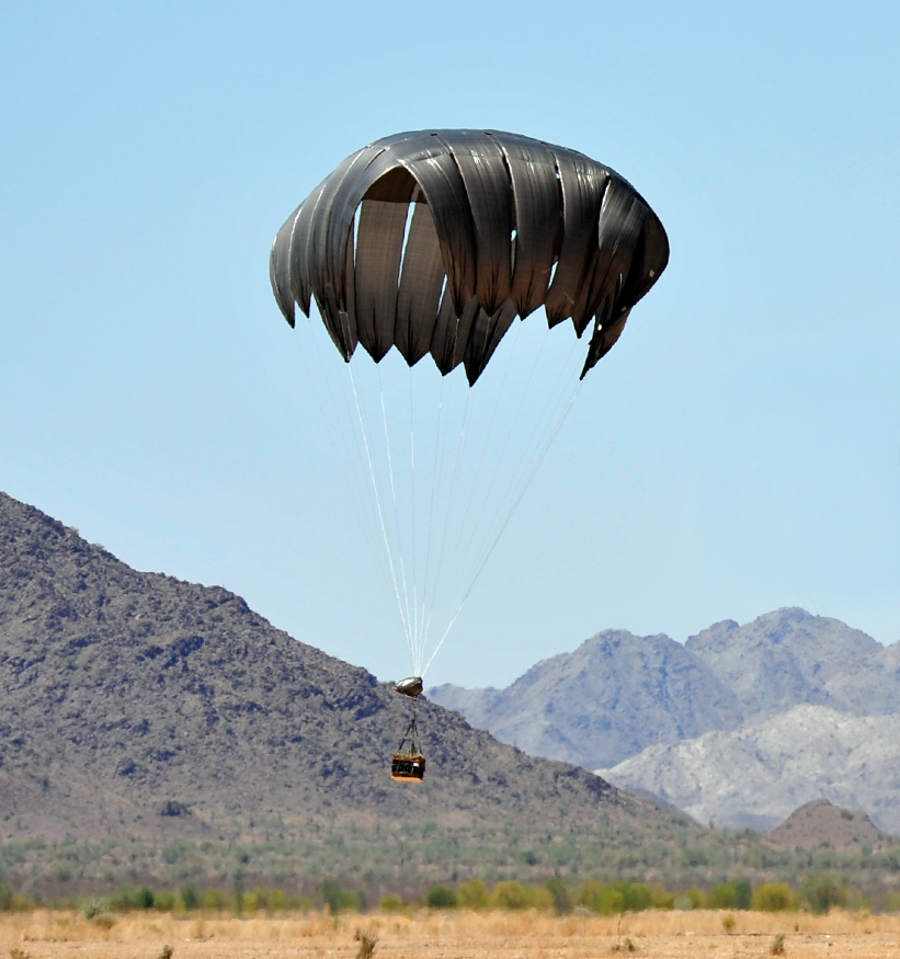 Low velocity parachute about to delivery payload to the ground. Mountains in background.